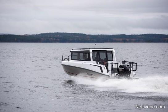 A white motorboat named "Falcon 17" speeds across a calm lake under a cloudy sky.